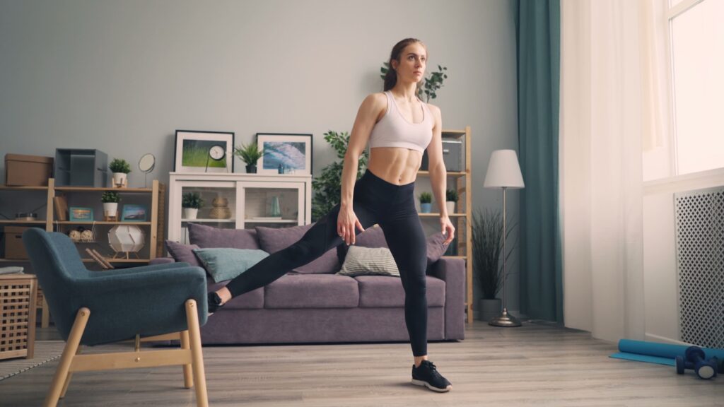 a woman in a sports bra top and leggings in a living room