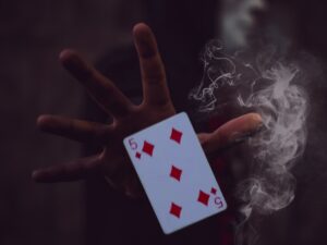 person holding 5 of Diamonds playing card