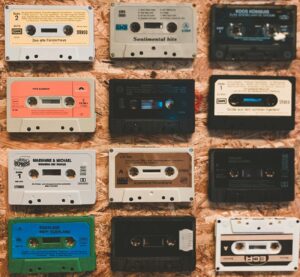 A nostalgic display of various vintage audio cassettes on a textured background.