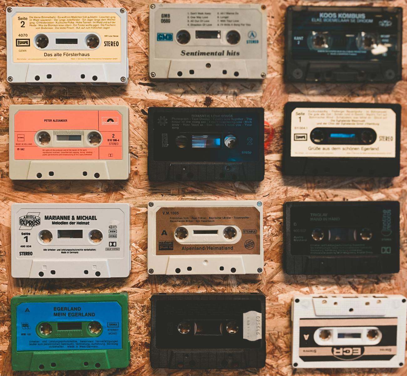 A nostalgic display of various vintage audio cassettes on a textured background.